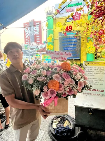 Khách nhận giỏ hoa chúc mừng tone hồng cam