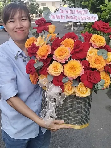 Khách nữ nhận giỏ hoa hồng đỏ, hồng cam chúc mừng chị em phòng làm việc