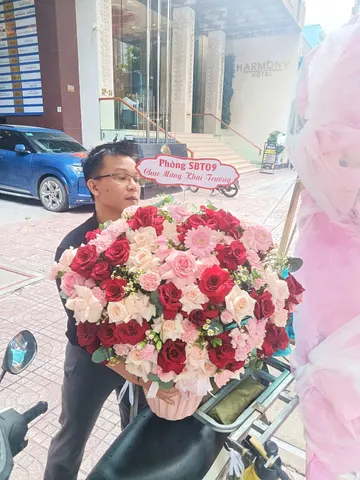 Khách nam nhận giỏ hoa hồng đỏ phấn chúc mừng