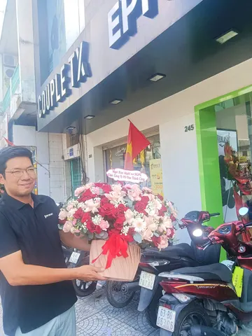 Khách nam nhận giỏ hoa hồng mừng khai trương cửa hàng