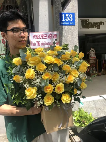 Khách nhận giỏ hoa hồng vàng mừng khai trương