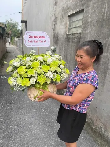 Khách nhận giỏ hoa hồng xanh cốm, cát tường trắng mừng sinh nhật do Hoarosa thiết kế