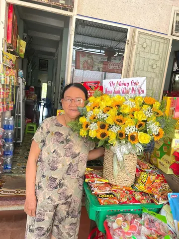 Chủ cửa hàng nhận giỏ hoa hướng dương mừng khai trương