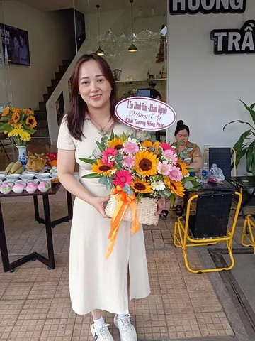 Khách nữ nhận giỏ hoa hướng dương mừng khai trương cửa hàng