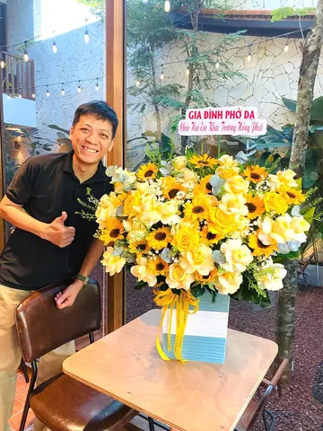 Chủ quán cà phê nhận giỏ hoa hướng dương mừng khai trương