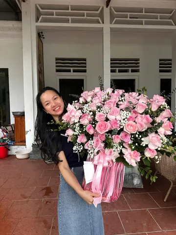 Khách nữ nhận lẵng hoa hồng phấn cỡ lớn
