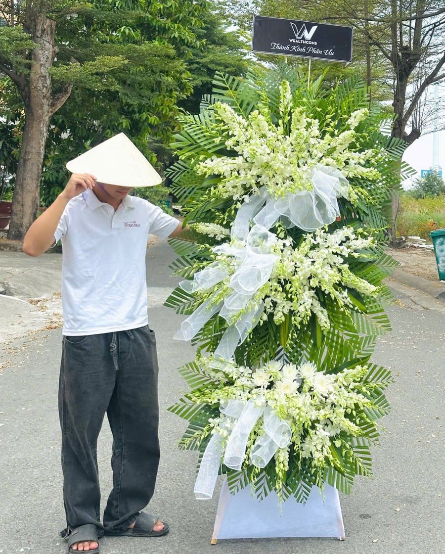 Kệ hoa viếng ba tầng lan trắng, cúc trắng trên nền lá xanh do Hoarosa giao tận nơi